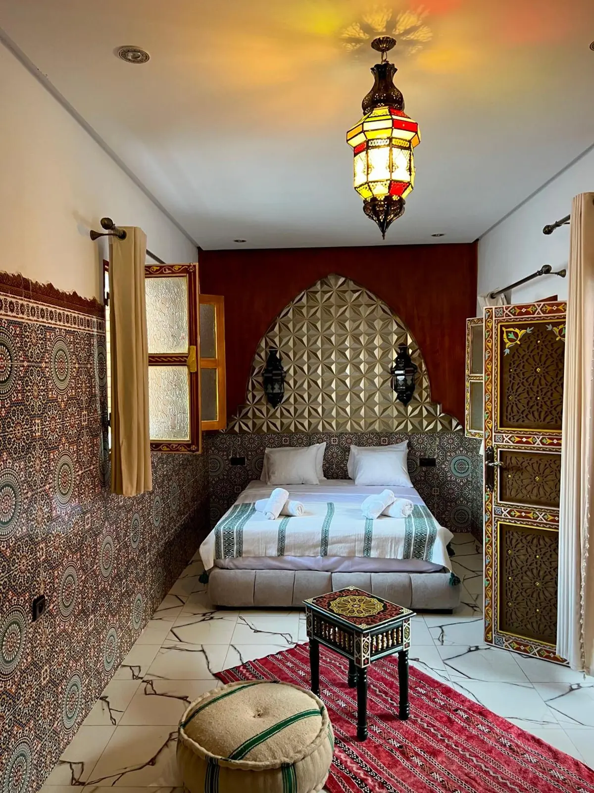 La Chambre Double Deluxe, son lit et sa tête de lit dorée