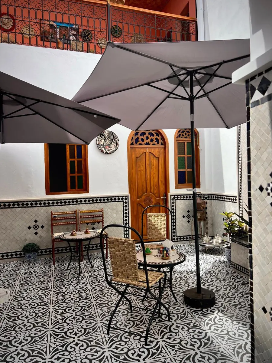 Le patio, ses parasols et ses fenêtres de bois