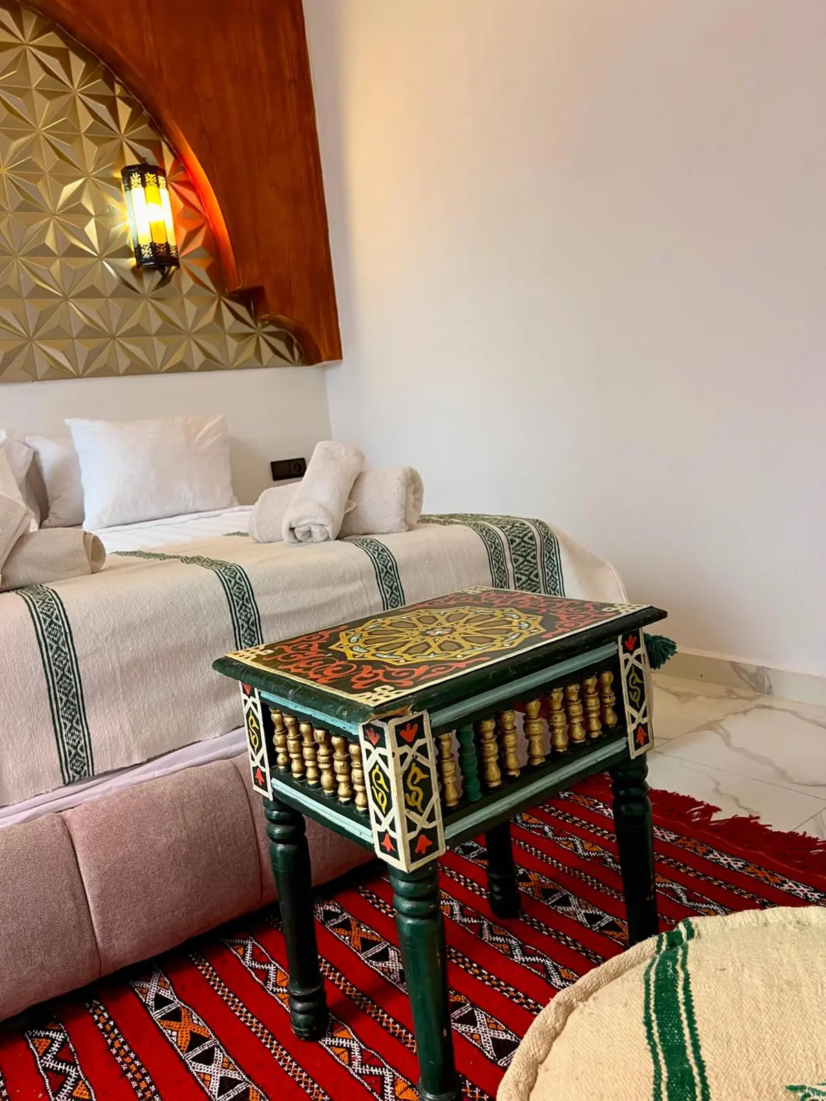 La Chambre Deluxe, son lit et sa tête de lit dorée