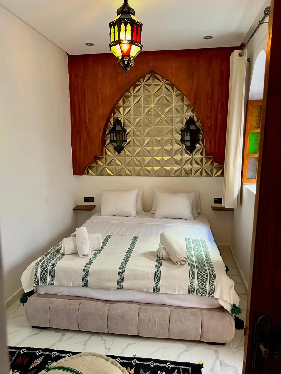 La Chambre Deluxe, son lit et sa tête de lit dorée